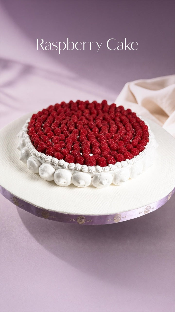 Raspberry celebration cake with hand-piped cream