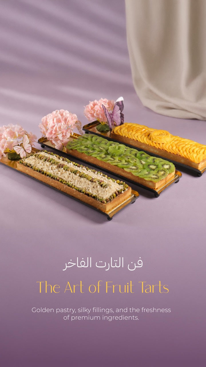 Three long fruit tarts topped with mango, kiwi and pistachio